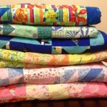 A stack of recently donated quilts