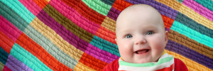 Laughing baby on a patchwork quilt